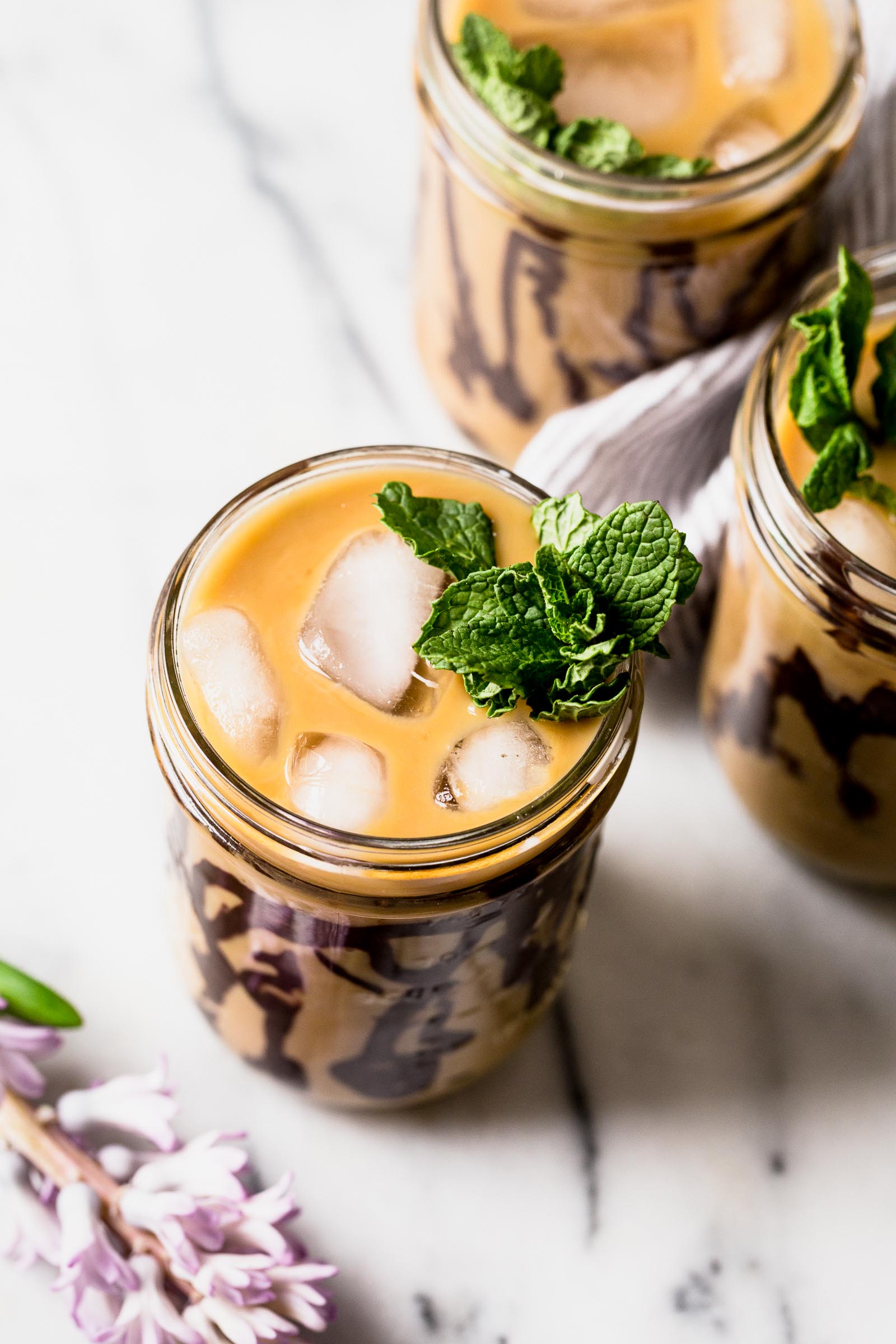 an easy & refreshing fresh mint cold brew iced coffee served with swirls of homemade dark chocolate syrup. the perfect springtime pick-me-up! #coldbrew #icedcoffee #minticedcoffee #dunkindonuts #dunkindonutsicedcoffee #easyicedcoffee #icedcoffeerecipe